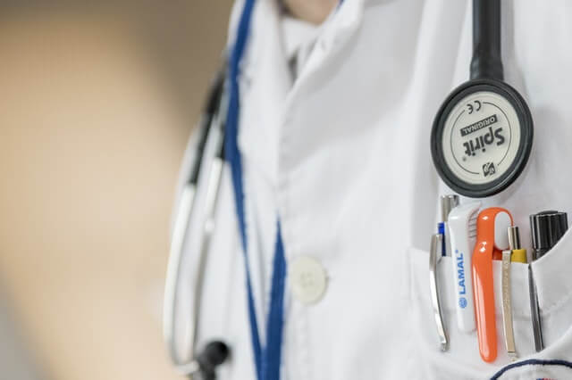 Photo of Doctor with Stethoscope. This photo is about medical gadgets, stethoscope, white coat, pens