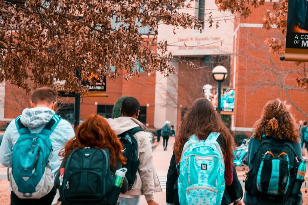 students wearing backpacks pexels photo