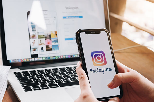 Boost Your Brand Awareness on Instagram. A woman holds Apple iPhone X with Instagram application on the screen. Instagram is a photo-sharing app for smartphones.