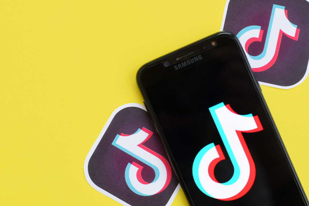 TikTok logo on Samsung smartphone screen on yellow background