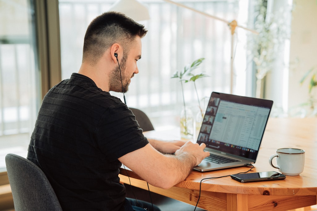 Young man working in home office and having a meeting conference via Zoom or  Hangouts or GoToMeeting.