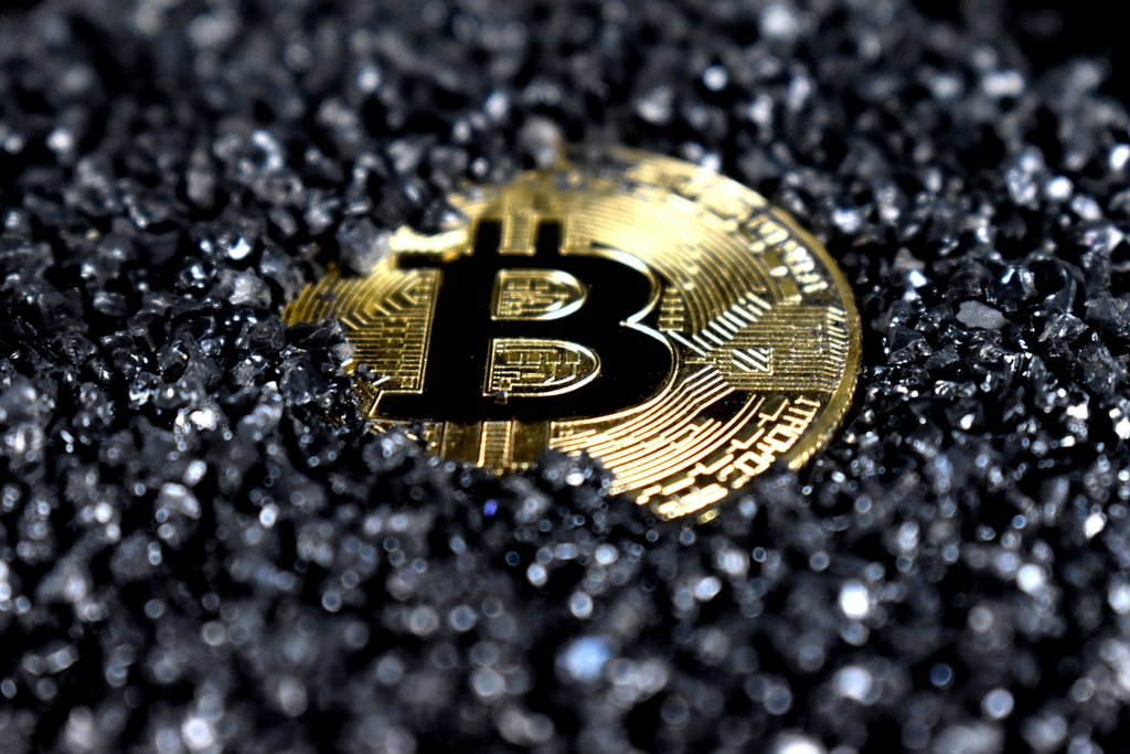 A Bitcoin covered in black crystals photo