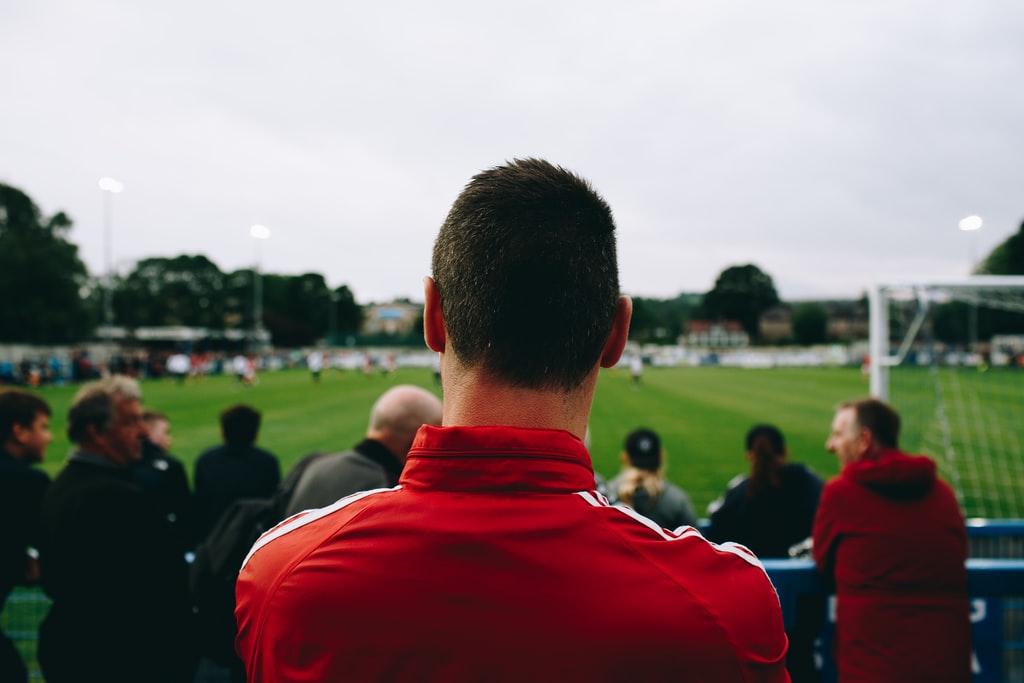 Man Standing While Watching Soccer During Daytime Photo