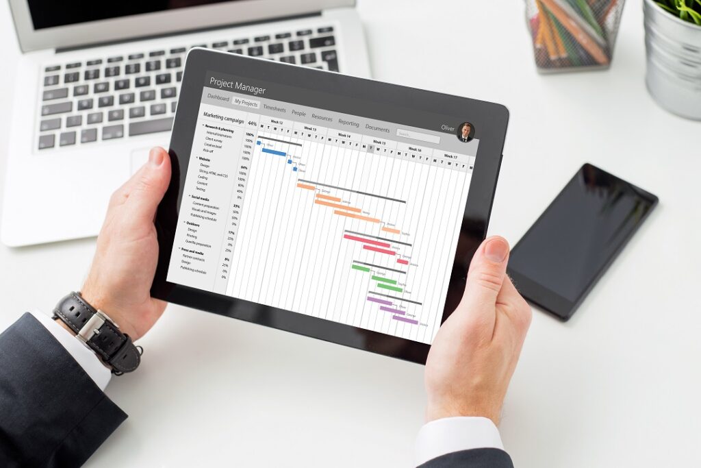 Project Manager looking at Gantt chart of the project schedule on tablet computer  