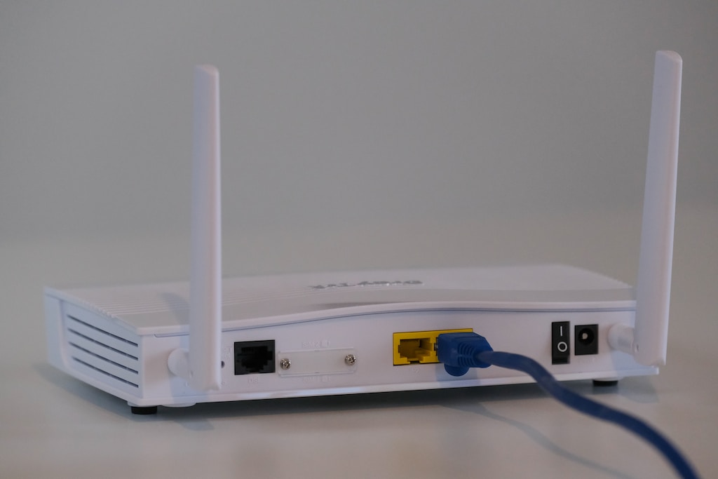 Broadband internet Wi-Fi router with ethernet cable plugged in to the back in the ethernet port.