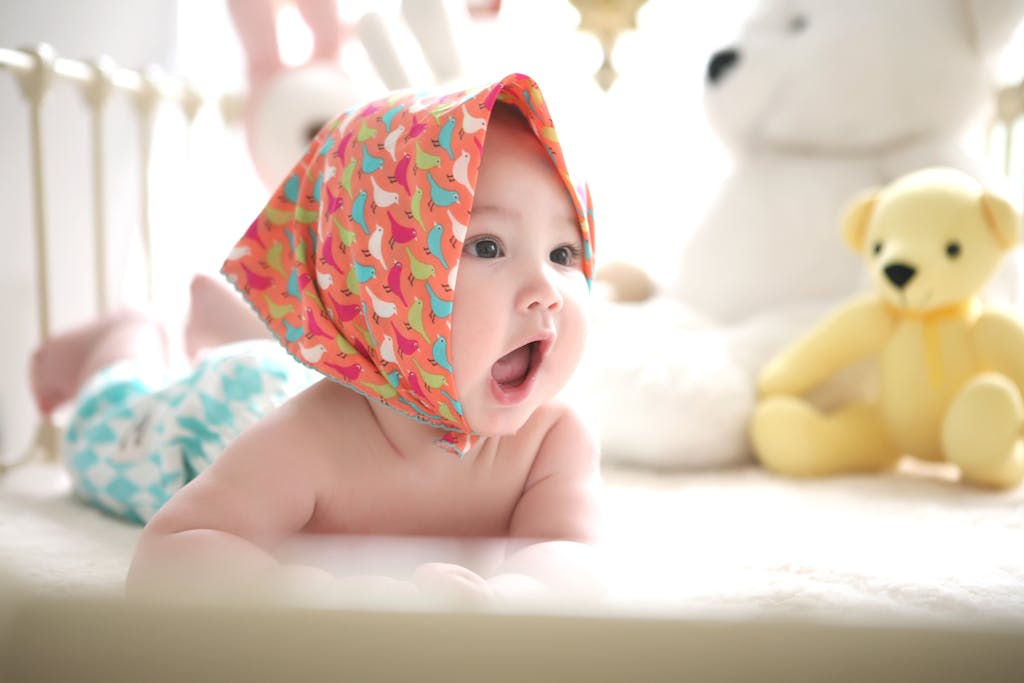 Cute Baby Wearing Head Scarf in Bed with Teddy Bears Toys