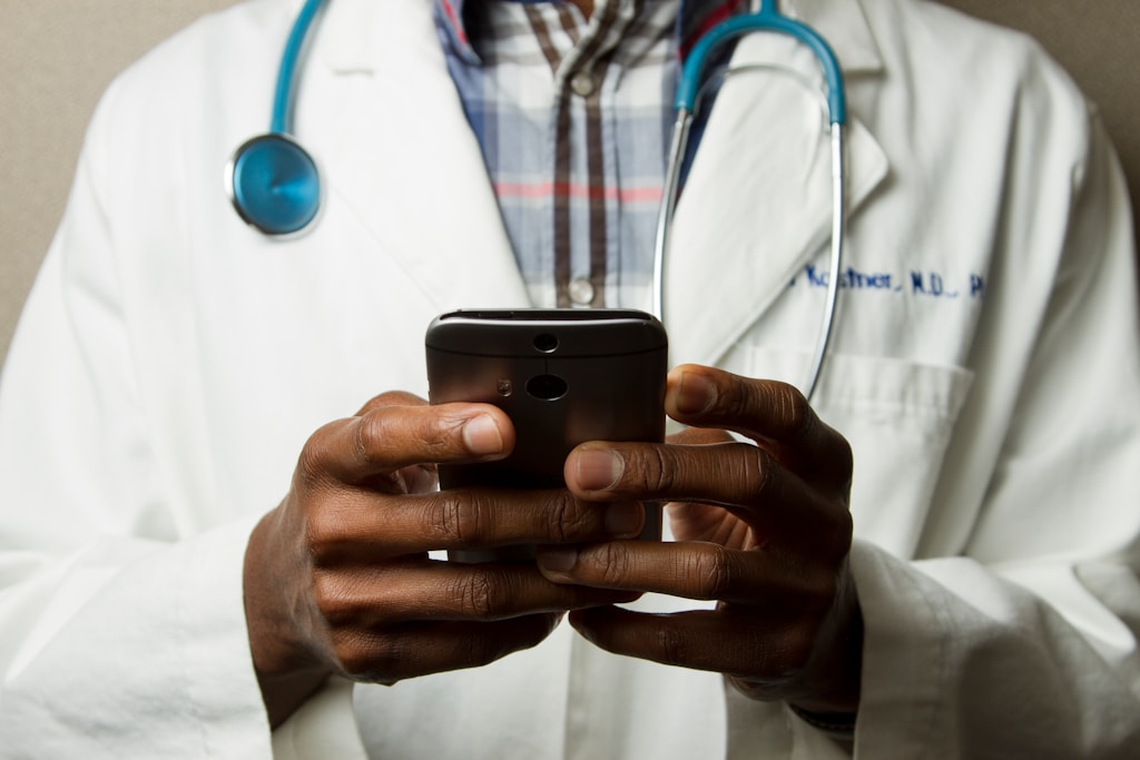 Doctor Holding Cell Phone. Cell phones and other kinds of mobile devices and communications technologies are of increasing importance in the delivery of healthcare.